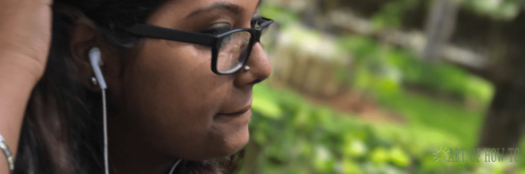 Picture of Writer in a garden with headphones on her ears.